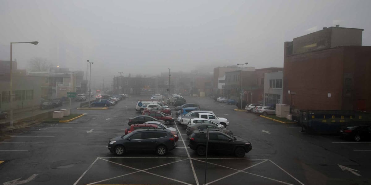 Vue des locaux de la Chambre de commerce et d'industrie de Saint-Jérôme, le stationnement de la rue De Villemure dans la brum