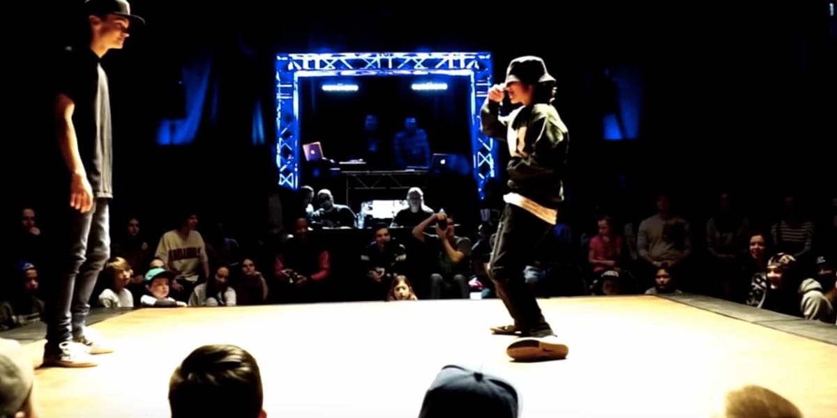 Un affrontement 1 vs 1 dans le cypher, un cercle, entouré du public dans la salle de l'École secondaire Des-Studios. Extrait