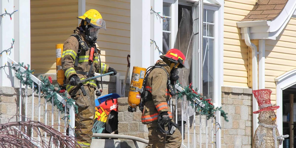 Deux pompiers sortent d'une maison de Prévost, sur la rue Bourque, le 29 mars 2016. Photos par Alexandre Parent Léveillé