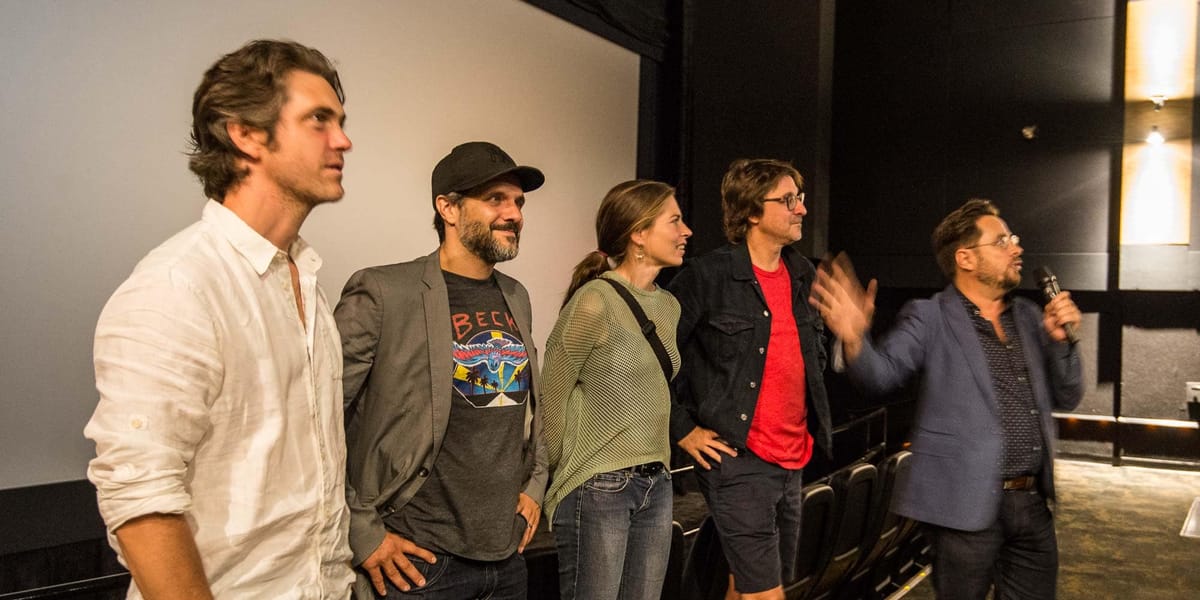 Devant l'écran du cinéma Carrefour du Nord, Maxim Gaudette, Marc Fournier, Noémie Godin-Vigneau, de la distribution de 9, le