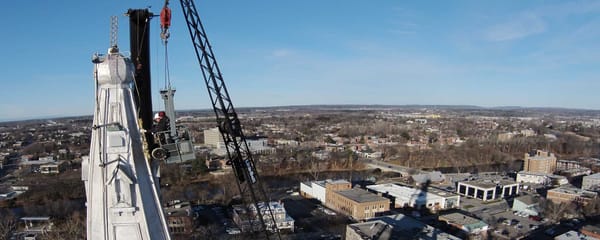 Les gens de Toitures PME s'affairent à couper le câble qui retient la croix sur le clocher de la cathédrale de Saint-Jérôme,