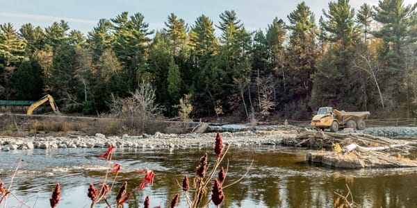 Une digue et des chemins d'accès ont été aménagés pour démolir le barrage.