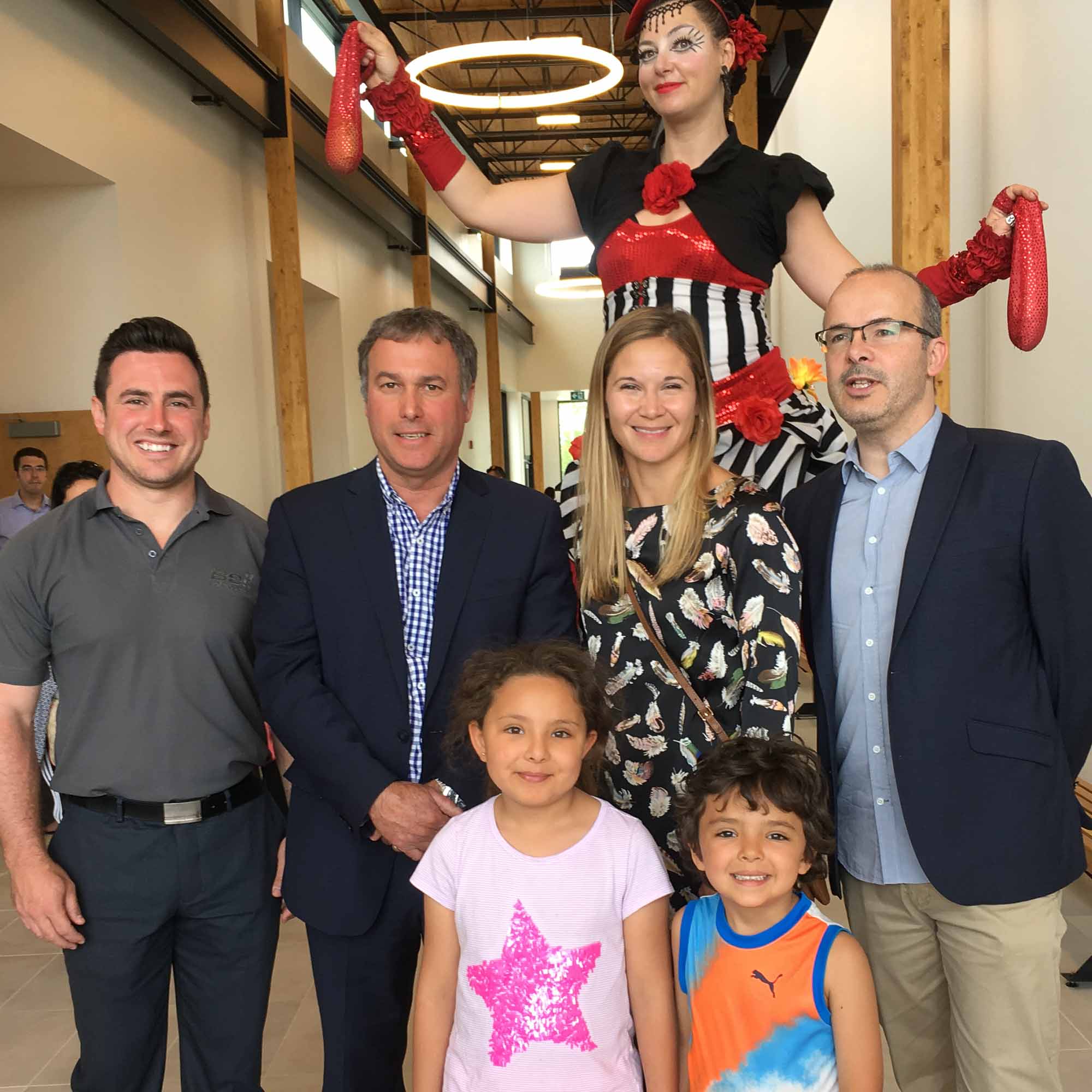 Dans le grand hall, Michael Nault de Bell Helicopter Textron, Jean Bouchard, maire de Mirabel, Isabelle Nuckle d’Hydro-Québec et Martin Brière, architecte et concepteur pour la firme BGLA, posent fièrement avec les enfants et une dame aux échasses.