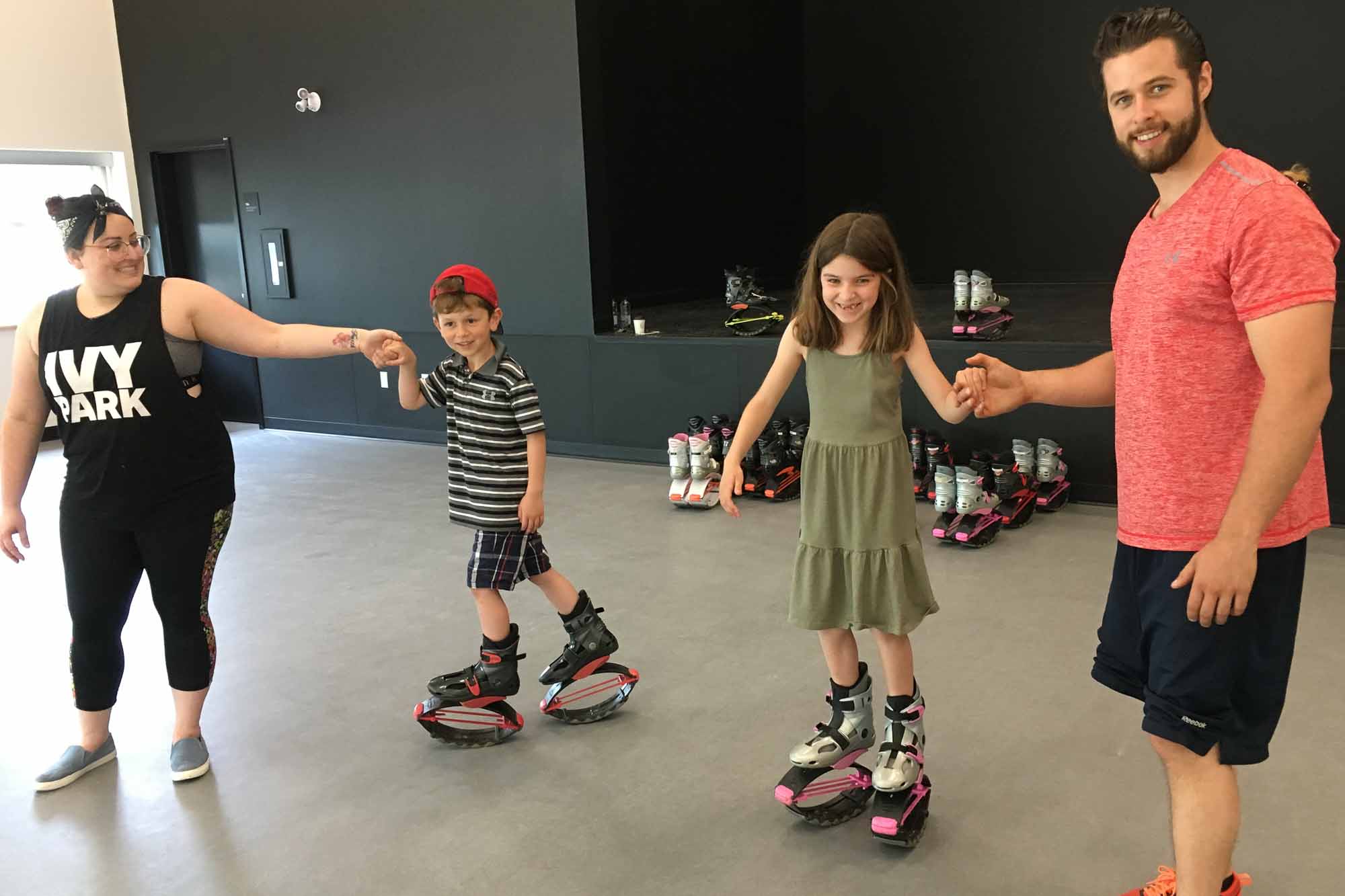 Jessica Desrosiers offrent une initiation de bottes trampolines (kangoo jumps) aux jeunes Tristan et Jade Ducharme dans une des salles disponibles pour des cours ou des ateliers.