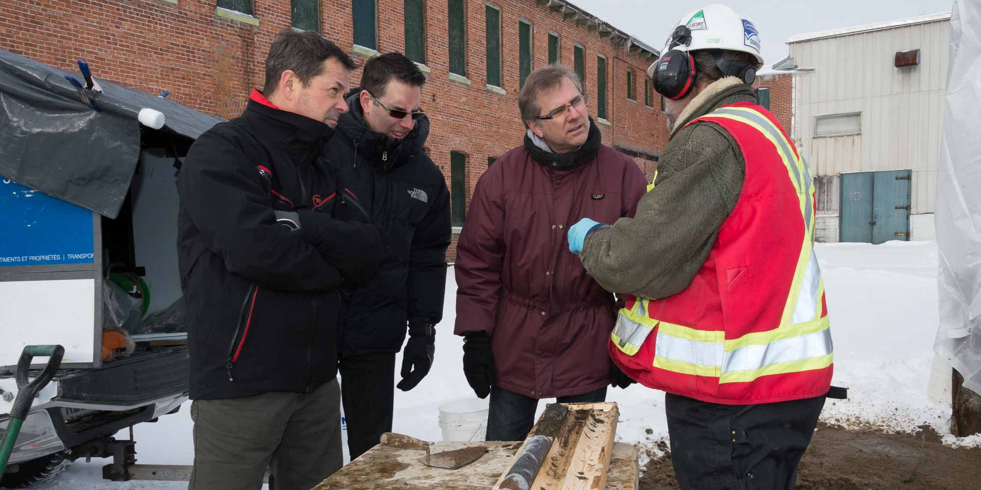 Pierre deschênes, Patrick LeBire et François Beauchêne discutent avec le responsable du forage le type de sol échantillonné à différents endroits sur le terrain.
