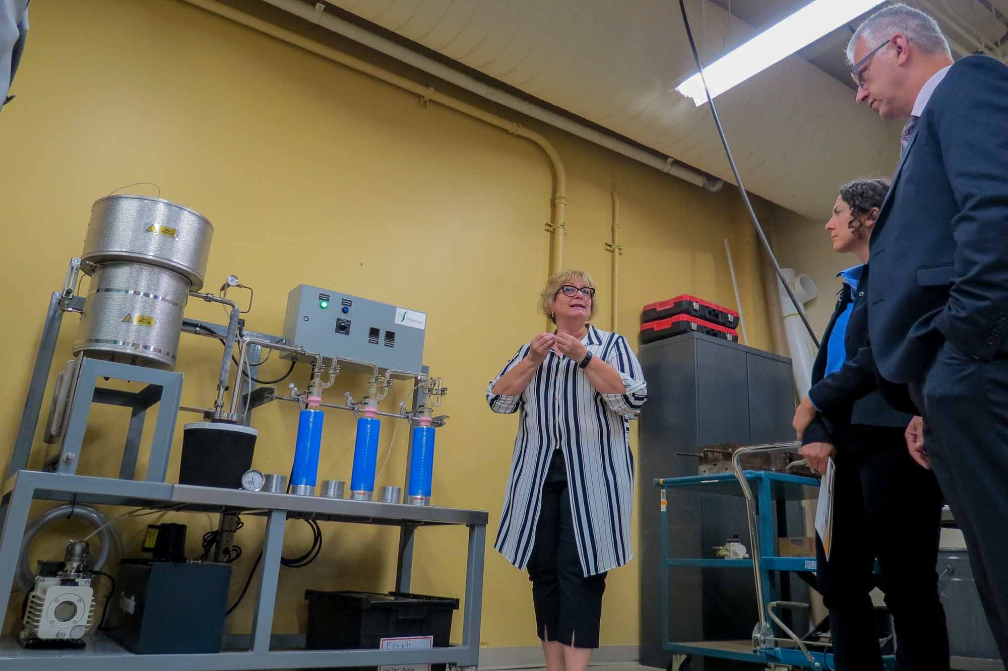 Janic Lauzon, directrice du CDCQ, explique l’utilisation d’un des nouveaux appareils, un réacteur à pyrolyse. À droite, on reconnaît le député d’Argenteuil-La Petite Nation, Stéphane Lauzon.