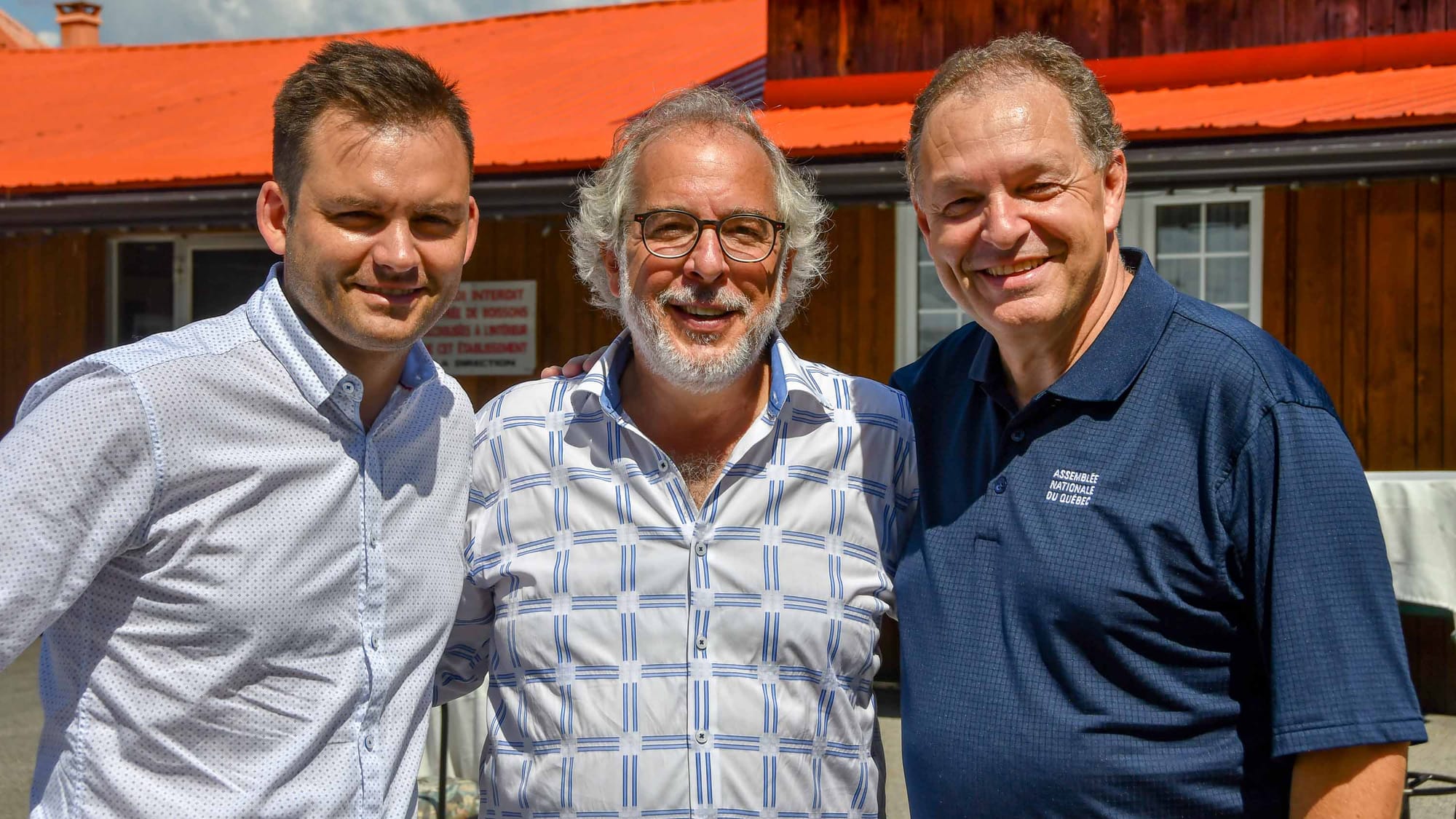 Le candidat du PQ dans Prévost Paul St-Pierre Plamondon et le candidat et député sortant Marc Bourcier entourent le député de Rivière-du-Nord Rhéal Fortin, lors de l'épluchette de blé d'inde organisée par celui-ci le 19 août 2018. Photo par Alain St-Jean