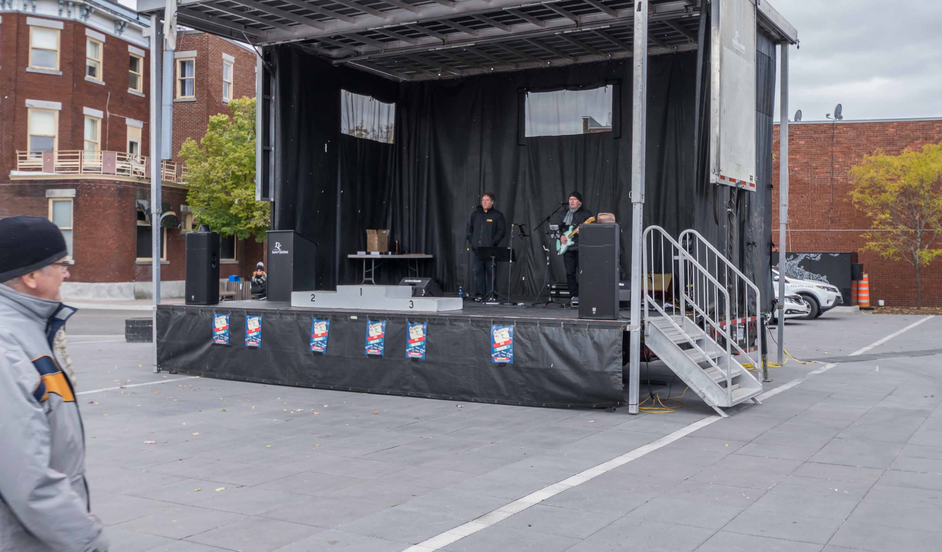 Il faisait froid dimanche pour le marathon du P'tit Train du Nord. Il n'y avait pas de foule sur la Place des festivités, mais derrière le podium encore désert qui attendait les gagnants, ces deux musiciens tentaient d'attirer un peu d'air tropical en chantant Oye Como Va...